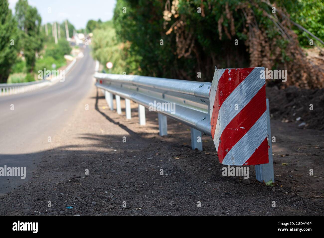 riflettori stradali rossi lungo la strada. recinzioni stradali in metallo di tipo barriera, primo piano. Sicurezza stradale e stradale. Vernice riflettente sul cartello. Barriera mediana Foto Stock