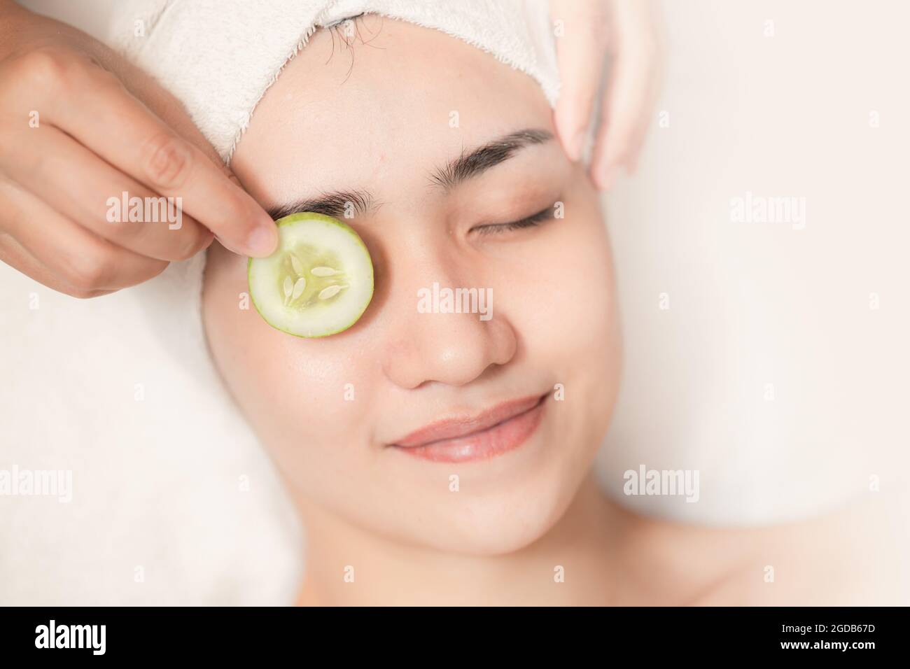 belle donne trattamento viso pelle occhi rughe cetriolo trattamento in salone spa relax sorriso felice. Foto Stock