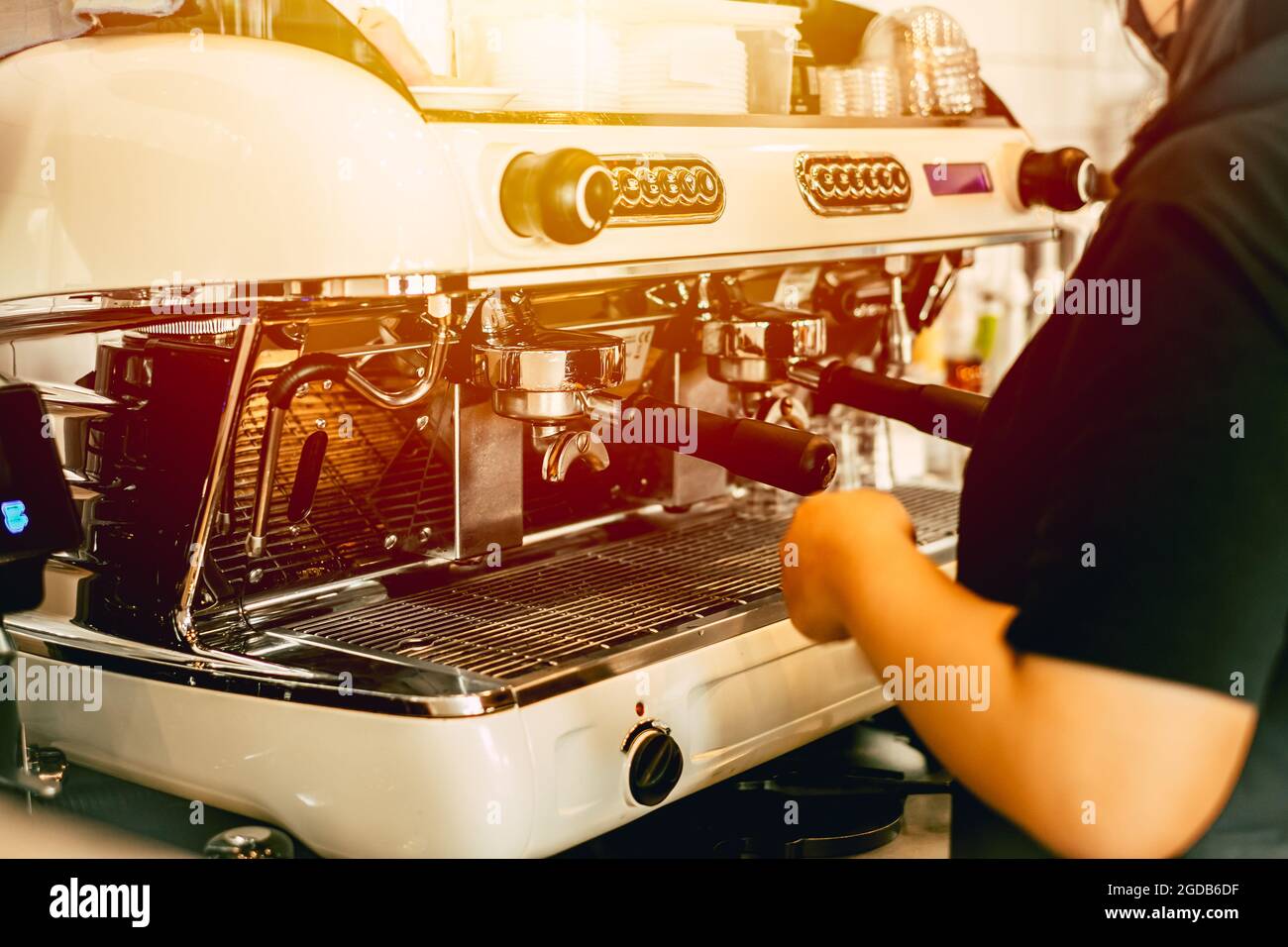 Il barista che lavora in un bar con macchina da caffè italiana fa un'immagine di caffè tonalità vintage. Foto Stock