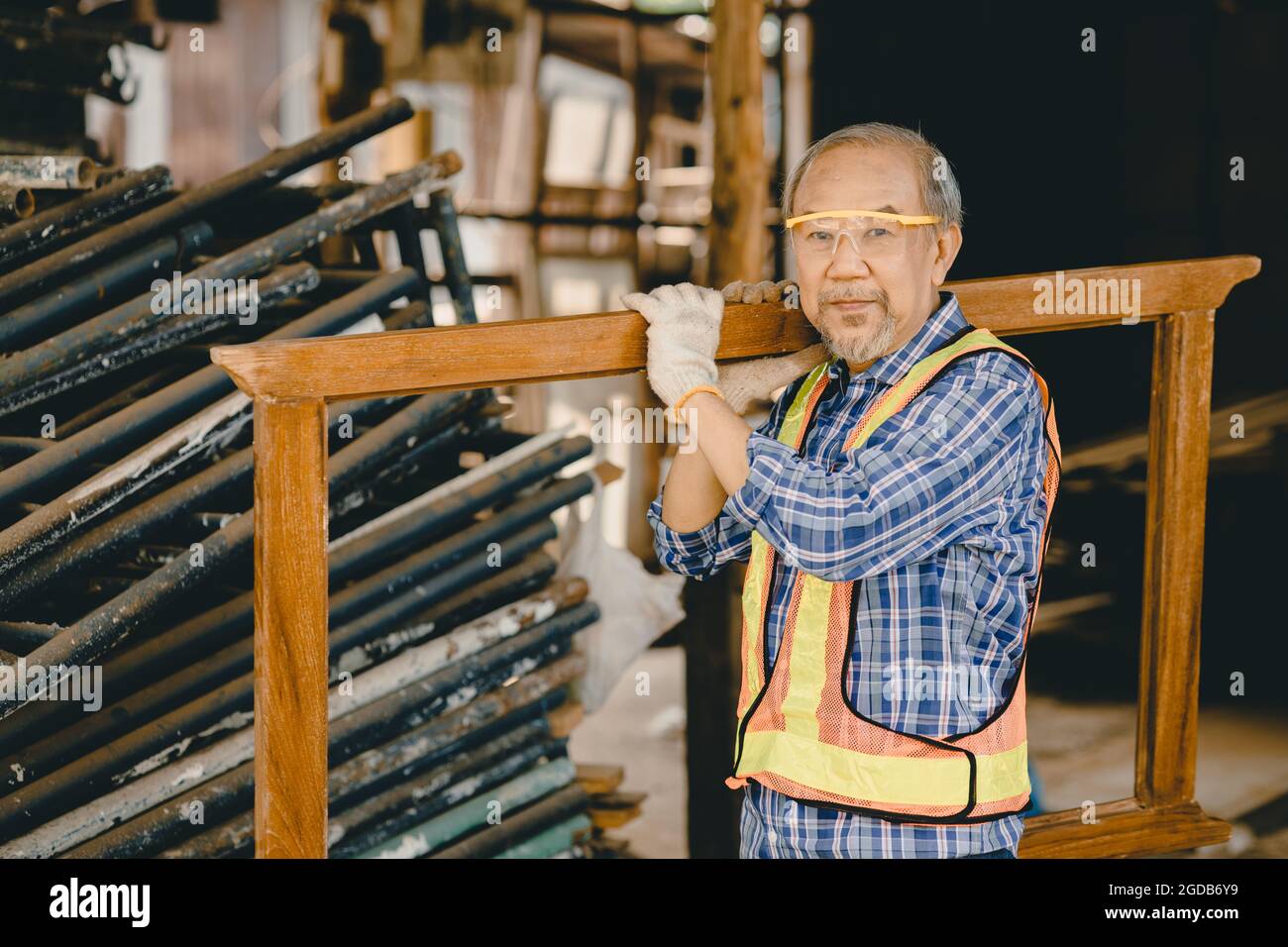 Lavoratore anziano sano e forte che lavora duro in cantiere con sicurezza di protezione. Foto Stock