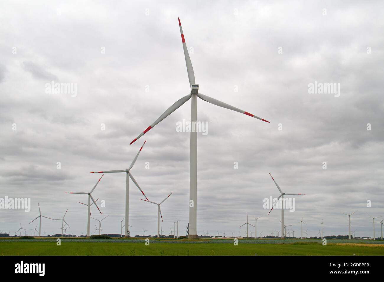 Produzione di energia eolica, paesaggio agricolo in Germania con molte turbine eoliche giganti Foto Stock