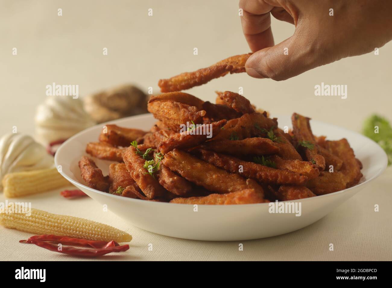 Frittelle croccanti fritte di mais per neonati o di mais per neonati preparate con un granoturco per bambini cotto a vapore immerso in una pastella di farina piccante. Una ricetta di base. Scatto su bianco Foto Stock