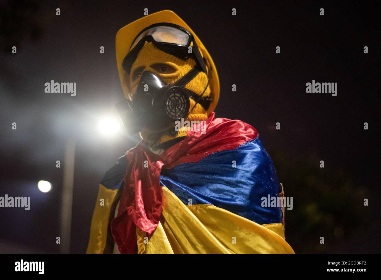 Bogotà, Colombia. 11 Agosto 2021. Un dimostratore di prima linea usa la bandiera colombiana mentre aumentano gli scontri tra i dimostranti e la polizia in rivolta della Colombia (ESMAD) nel nord di Bogotà, Colombia, adnista lo sfratto e la deforestazione di una riserva naturale il 11 agosto 2021. Credit: Long Visual Press/Alamy Live News Foto Stock