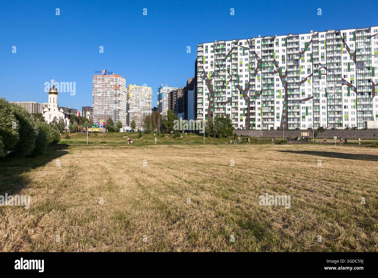 San Pietroburgo, Russia-circa Giu, 2021: Il microdistretto Kudrovo con il parco Okkervil e nuovi edifici con una chiesa, la regione di Leningrado Foto Stock