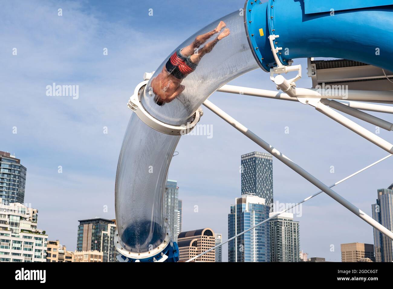 Guy cavalcando attraverso il tunnel dello scivolo acquatico sul norvegese Encore Foto Stock