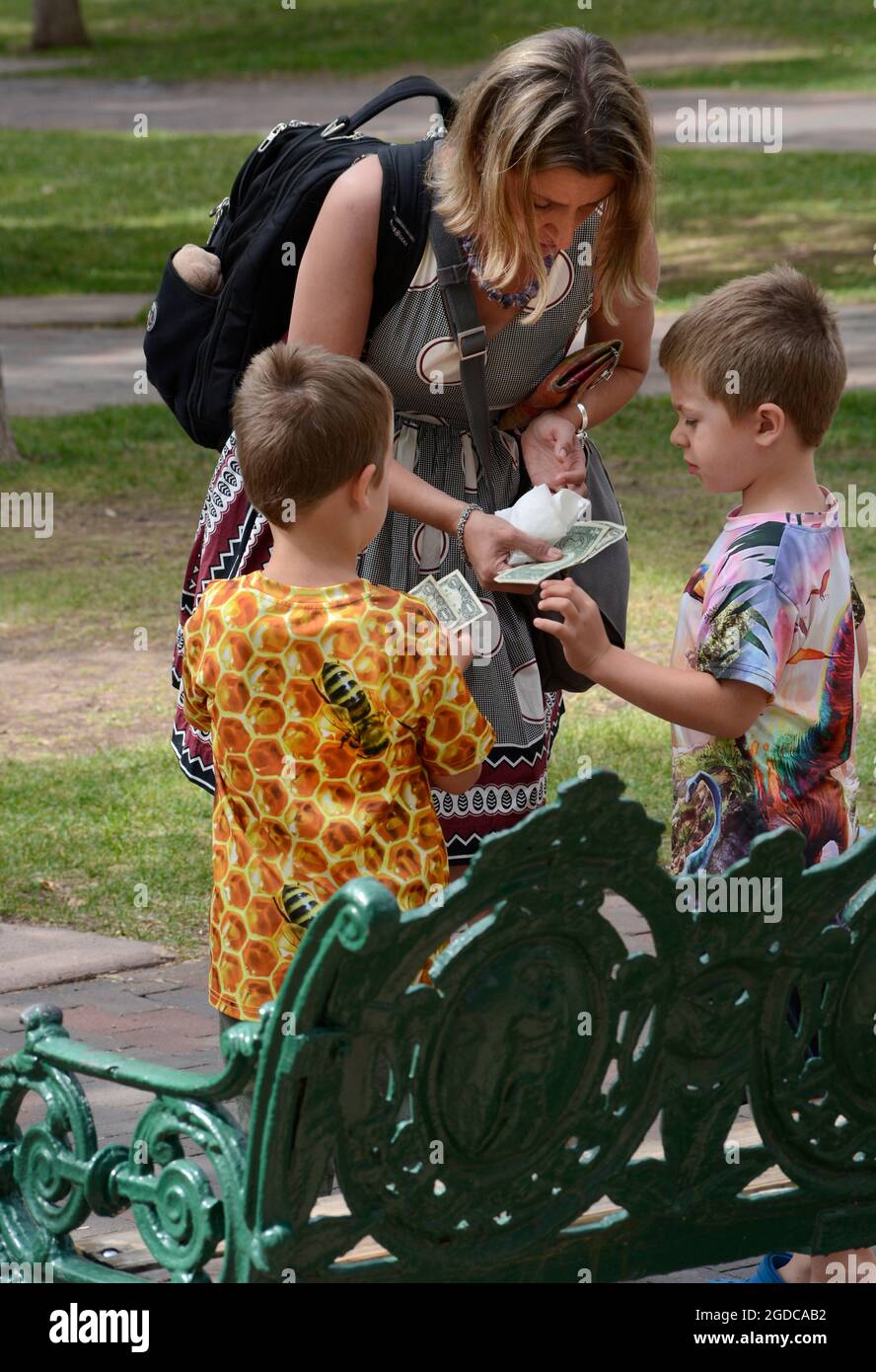 Una donna dà i suoi due figli giovani soldi per acquistare bevande analcoliche e gelati in vendita a Santa Fe, New Mexico. Foto Stock