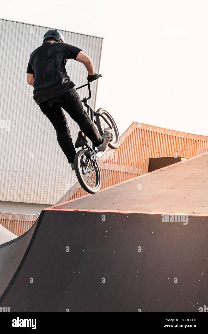 Un giovane pilota su una BMX fa trucchi in aria. BMX Freestyle in uno skate Park. Foto Stock