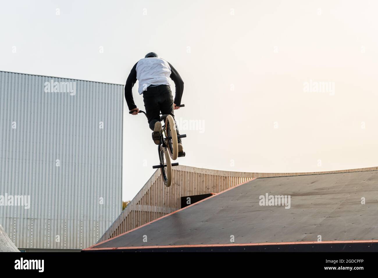Un giovane pilota su una BMX fa trucchi in aria. BMX Freestyle in uno skate Park. Foto Stock