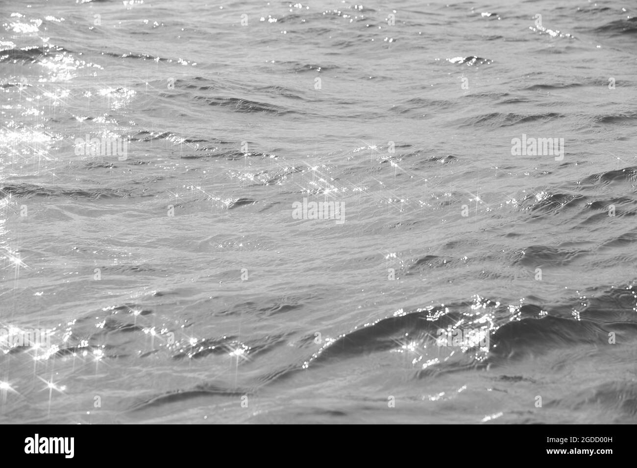 Dettaglio di una luce solare che si riflette in un mare scintillante. sparkler in acqua - sfondo. Acqua di mare con luce solare e ripple. Natura potente e pacifica c Foto Stock