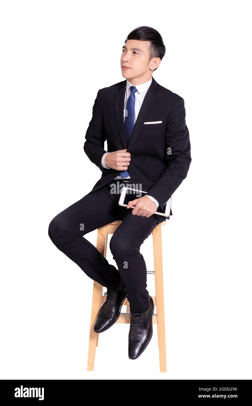 Giovane uomo d'affari seduto su una sedia con un tablet. Isolato su sfondo bianco. Foto Stock