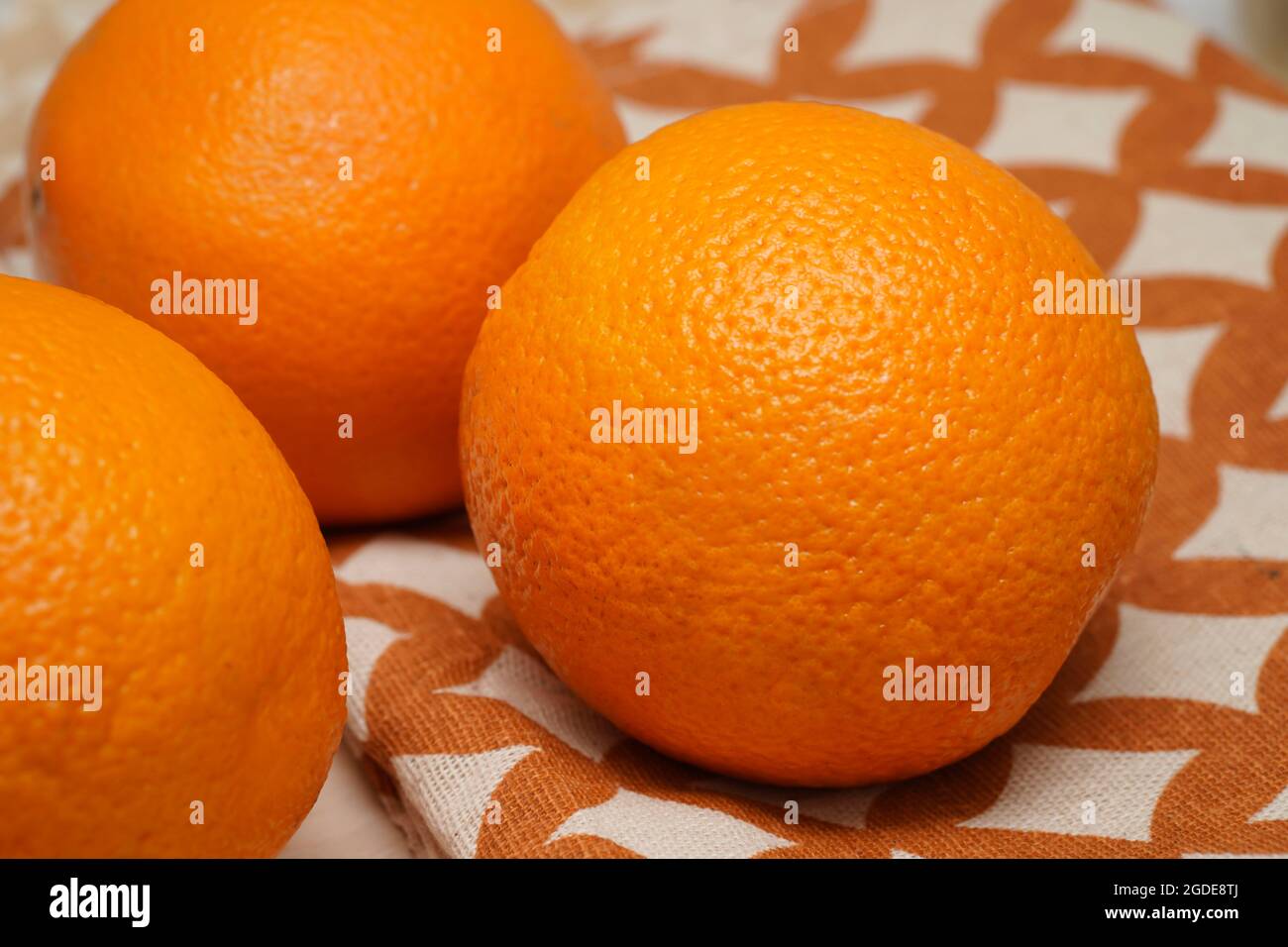 Primo piano tre frutta arance intere su sfondo di legno. Foto Stock