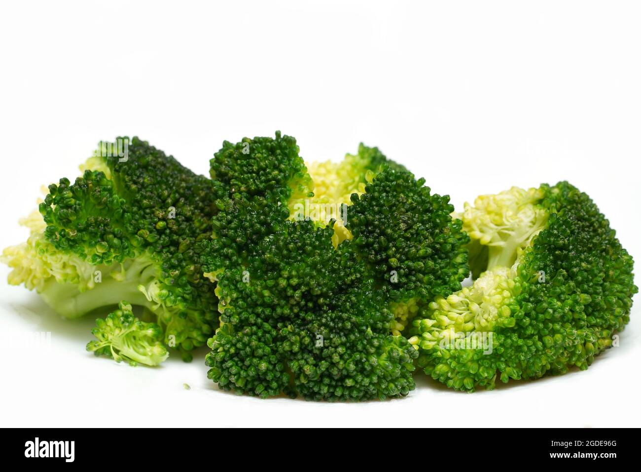 Infiorescenze di broccoli maturi cotti con olio d'oliva isolato su fondo bianco. Foto Stock