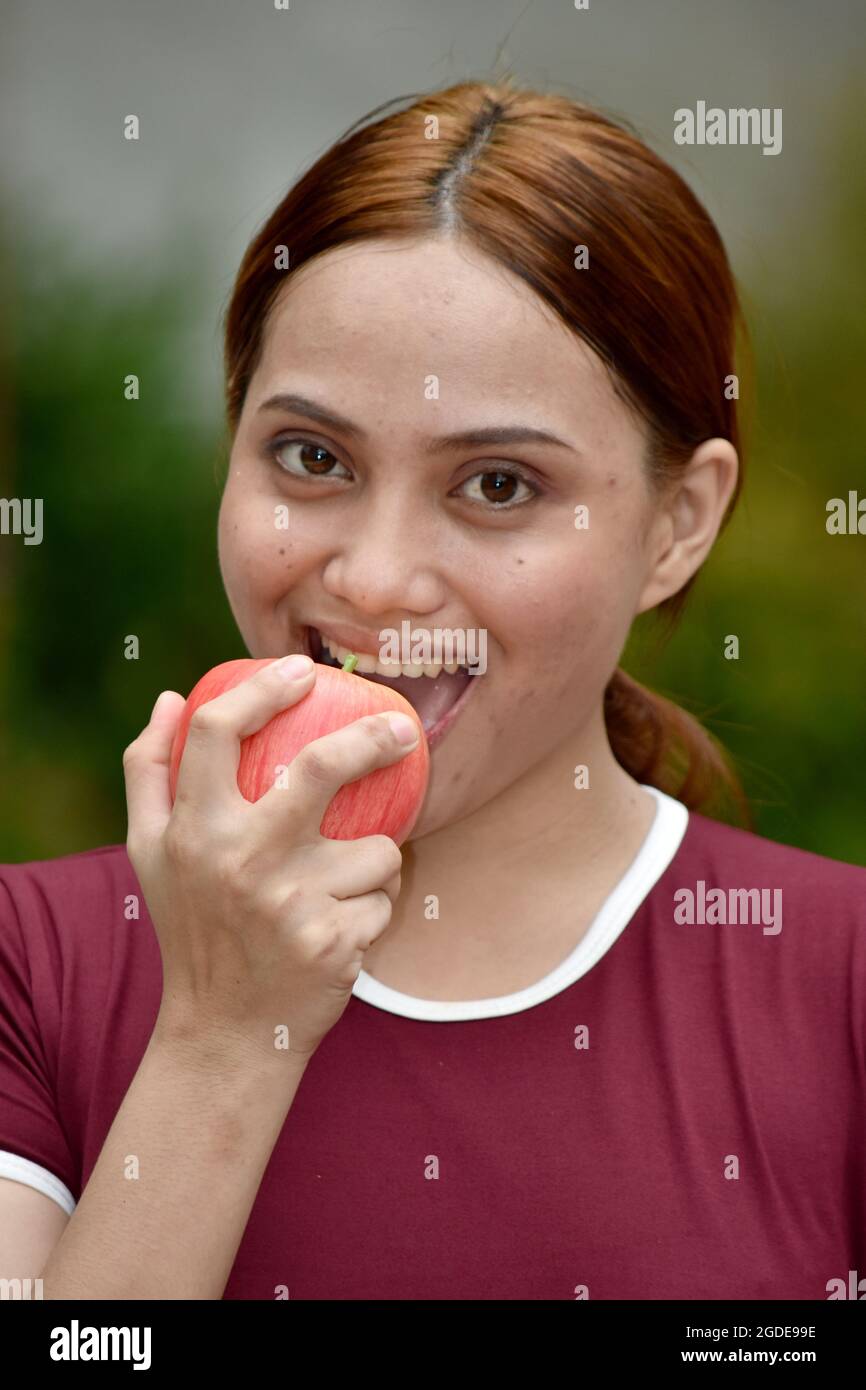 Bella Redhead femmina mangiare con le mele al Parco Foto Stock
