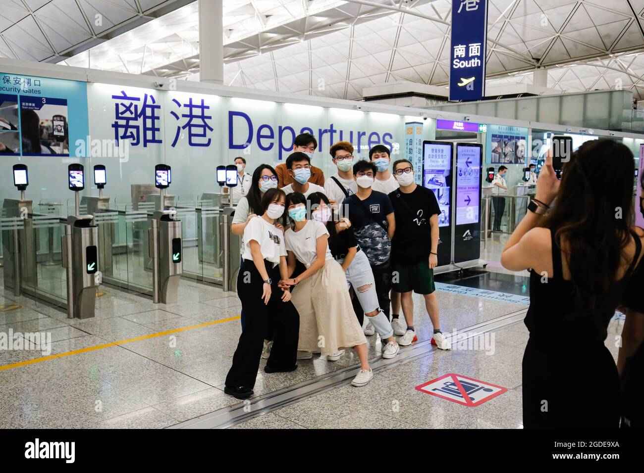 La gente posa per le foto con i loro amici e famiglie mentre partono dall'aeroporto internazionale di Hong Kong. Il governo di Hong Kong ha affermato che circa diciannove mila Hong Kong hanno lasciato il paese per ragioni diverse. Foto Stock