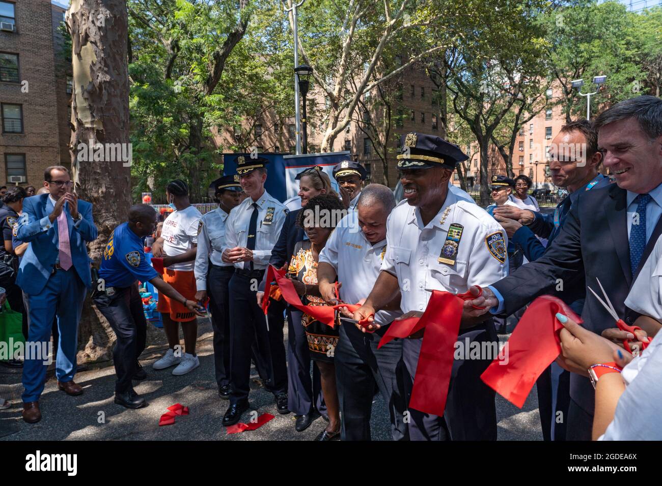 New York, Stati Uniti. 12 agosto 2021. NEW YORK, NY - AGOSTO 12: I partecipanti hanno tagliato il nastro ad un evento di apertura di Queensbridge Houses Basketball Court il 12 Agosto 2021 nel Queens Borough di New York City. Il New York Police Department rinnova il campo di pallacanestro presso le NYCHA Queensbridge Houses attraverso l'uso di fondi per le confische. È uno dei 15 campi da pallacanestro in tutta la città che il NYPD sta rinnovando. Il progetto da 4 milioni di dollari è finanziato da busti di farmaci. Credit: Ron Adar/Alamy Live News Foto Stock