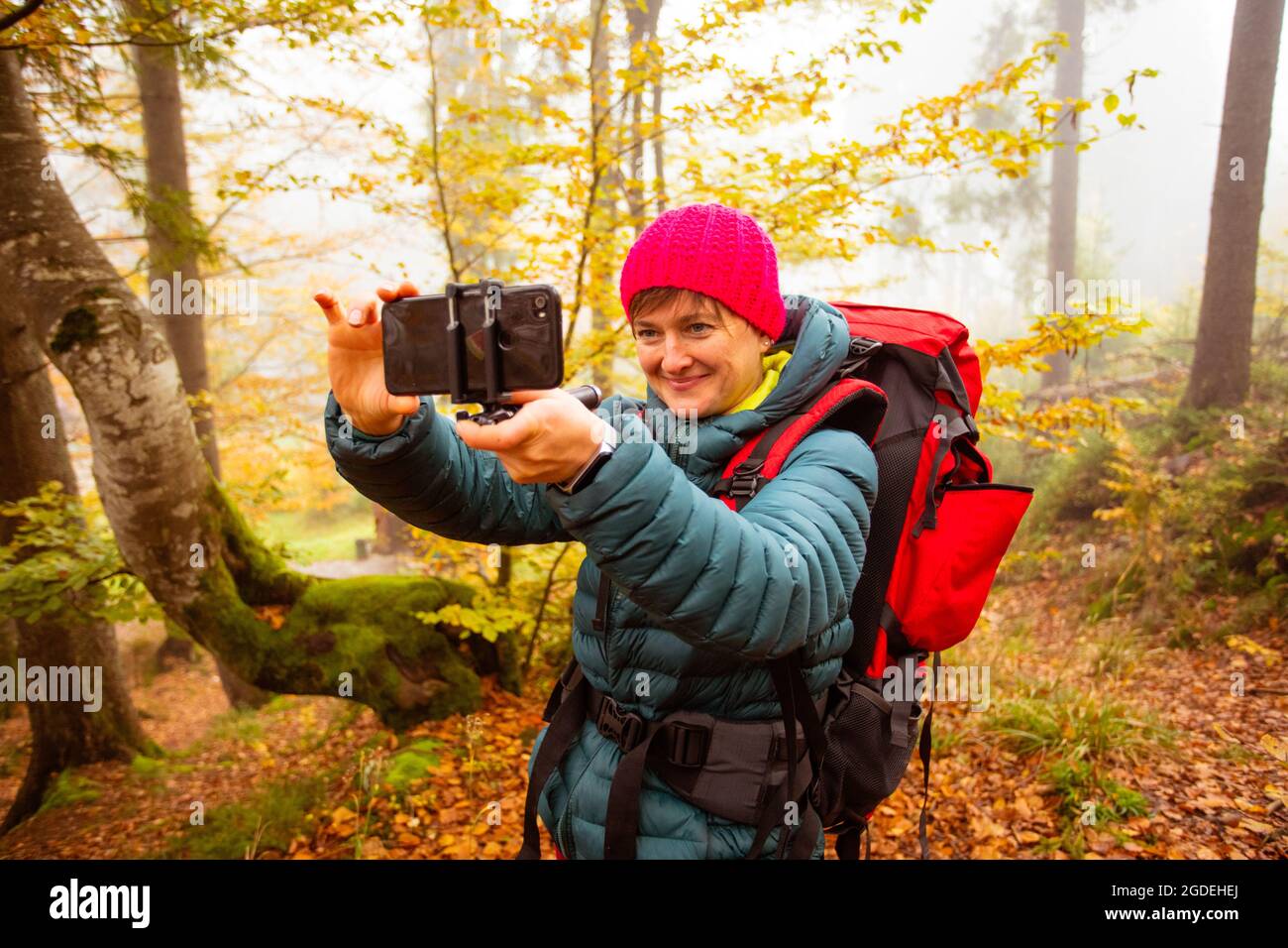 Donna sta prendendo un selfie mentre camminando nella foresta Foto Stock
