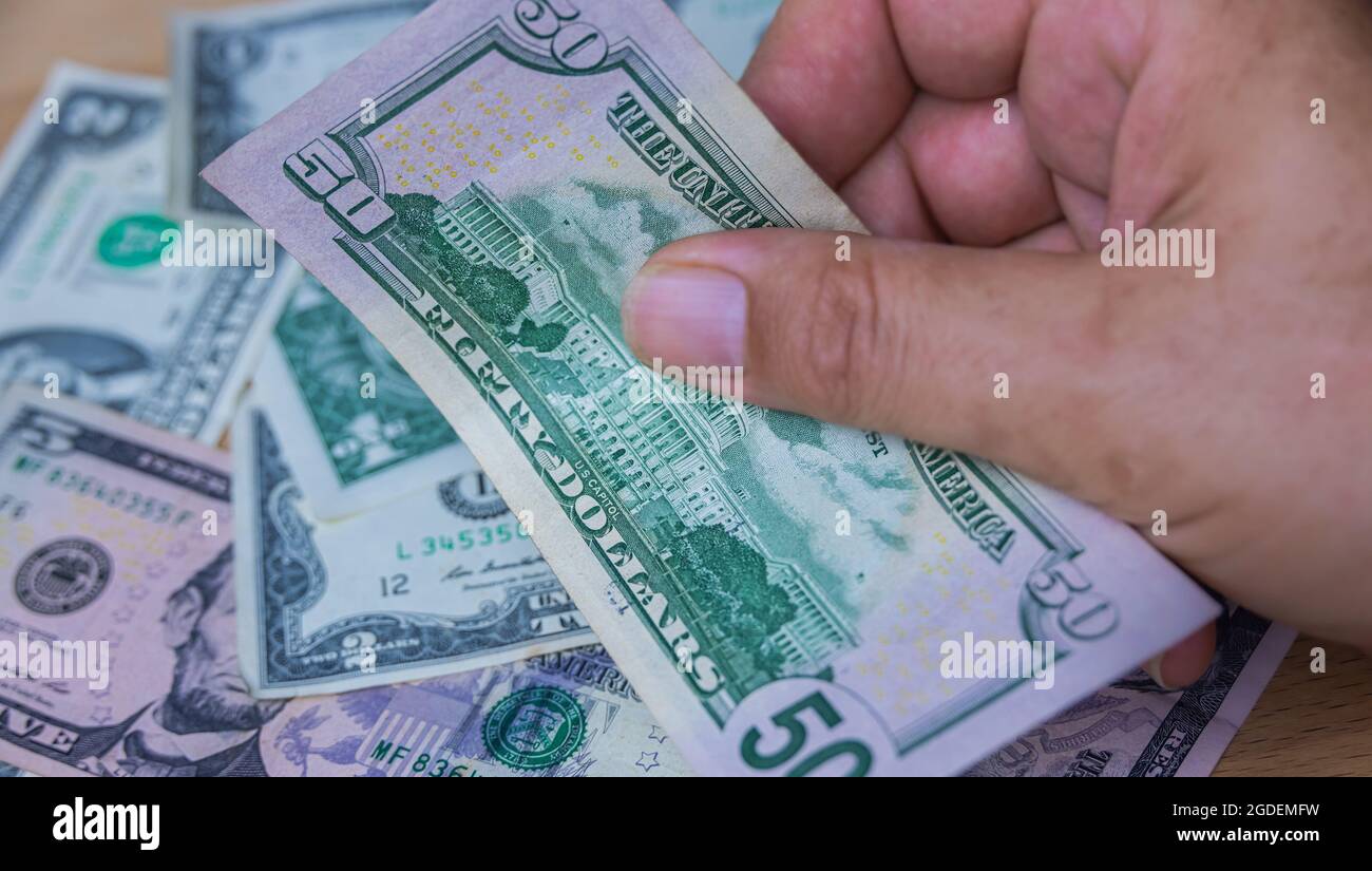 Mano maschile tenere una banconota da dollari USA fan, la valuta degli stati uniti. Primo piano Paper Money degli Stati Uniti. I dollari sono la valuta mondiale. Mani dell'uomo anziano Foto Stock