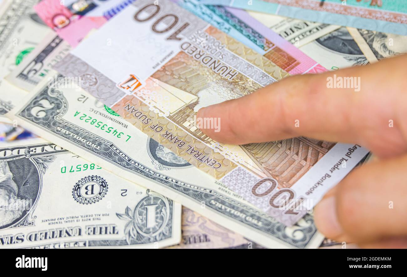 Mano maschile tenere 100 sterline sudanesi banconota, la valuta del Sudan. Primo piano carta denaro del paese arabo con un'inflazione elevata. Mostra mani vecchio uomo Foto Stock