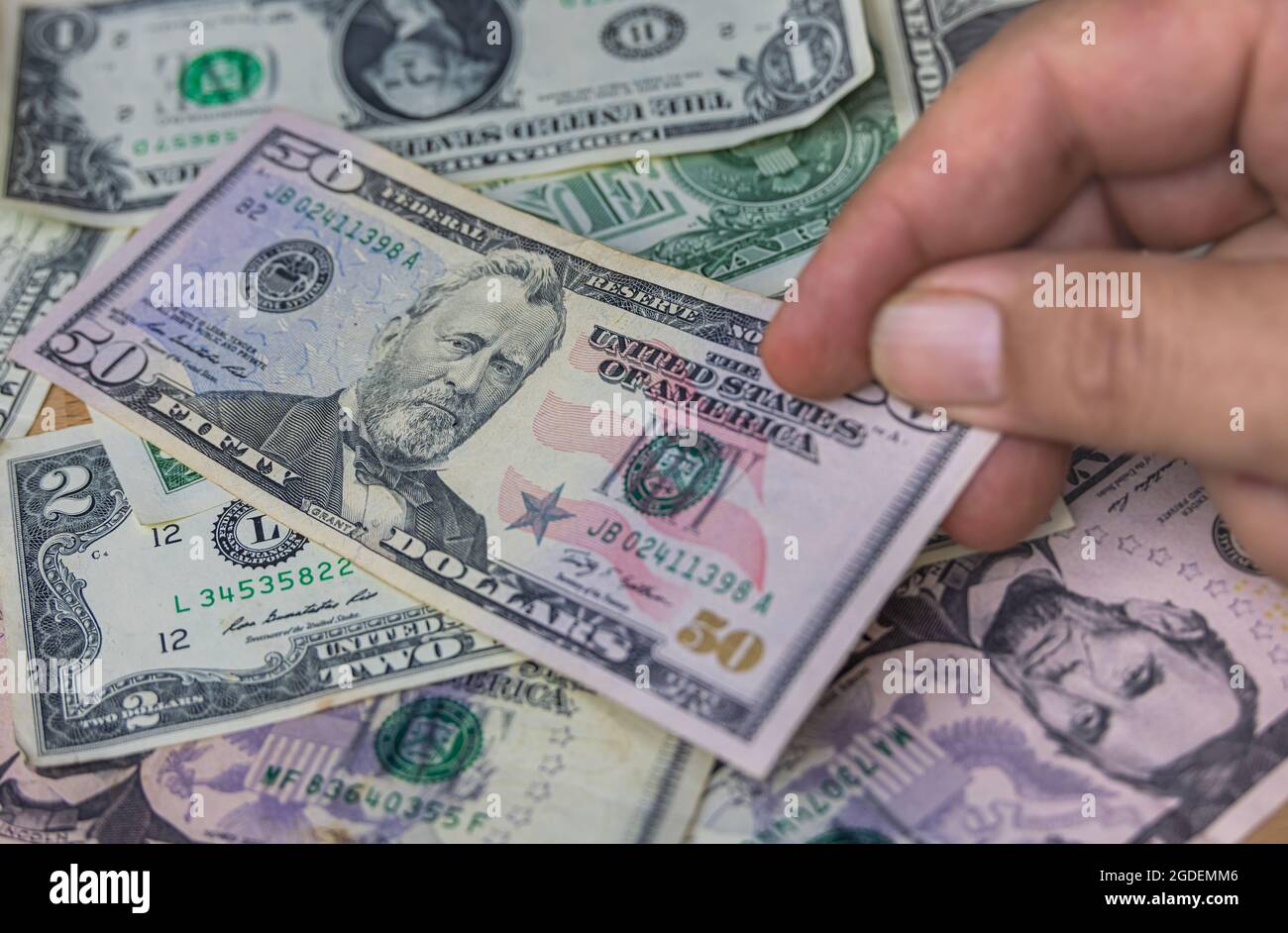 Mano maschile tenere una banconota da dollari USA fan, la valuta degli stati uniti. Primo piano Paper Money degli Stati Uniti. I dollari sono la valuta mondiale. Mani dell'uomo anziano Foto Stock