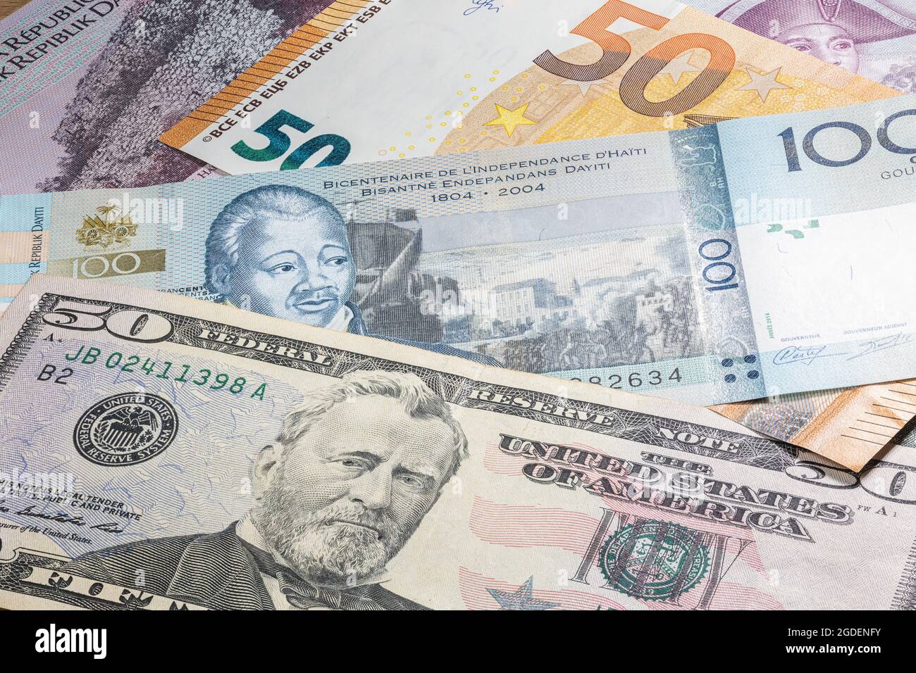 Primo piano fino a 100 Gourde della Repubblica di Haiti tra 50 dollari USA e 50 banconote in euro. Cento banconote di Gourde del paese caraibico Hait Foto Stock