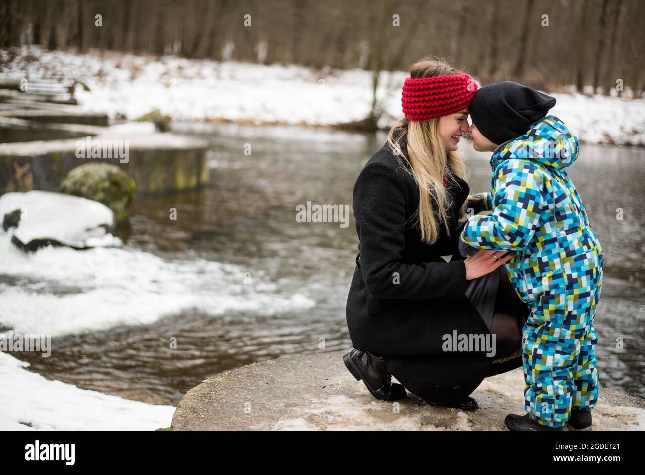 Giovane madre con suo figlio in inverno su un lago. Foto Stock
