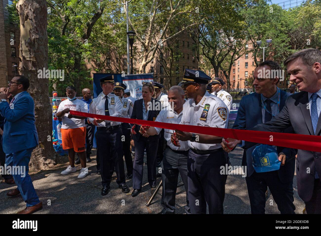 New York, Stati Uniti. 12 agosto 2021. I partecipanti hanno tagliato il nastro in un evento di apertura del Queensbridge Houses Basketball Court nel Queens Borough di New York City.il Dipartimento di polizia di New York rinnova il campo di pallacanestro presso le NYCHA Queensbridge Houses attraverso l'uso di fondi per le forfaitures. È uno dei 15 campi da pallacanestro in tutta la città che il NYPD sta rinnovando. Il progetto da 4 milioni di dollari è finanziato da busti di farmaci. (Foto di Ron Adar/SOPA Images/Sipa USA) Credit: Sipa USA/Alamy Live News Foto Stock