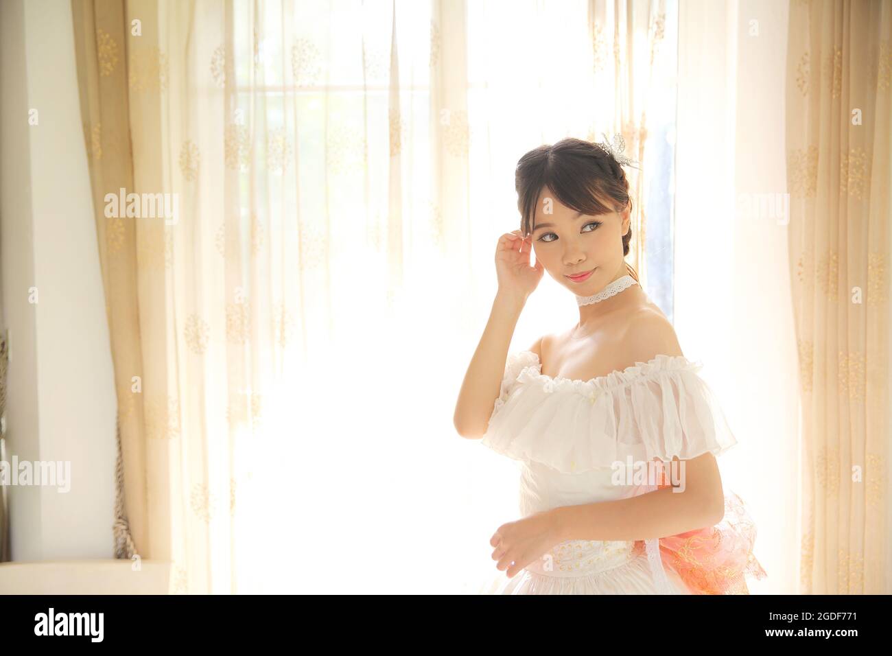 Sposa Asiatica in camera interna di abbigliamento bianco Foto Stock