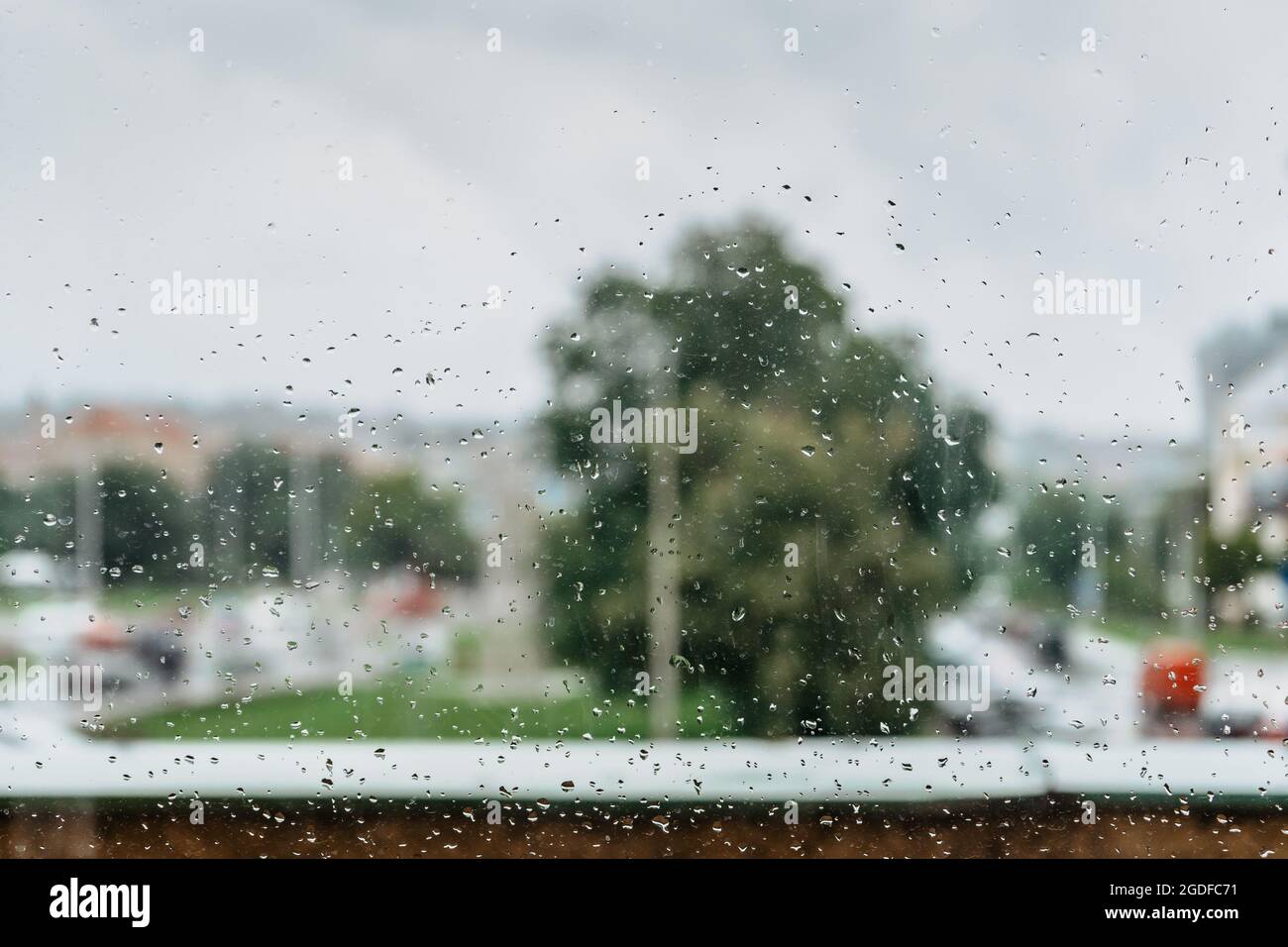 Gocce di pioggia durante la pioggia in day.View esterno finestra, vetro con sfondo sfocato.acqua gocciolina che scorre giù il surface.Wet vetro, cattivo tempo Foto Stock