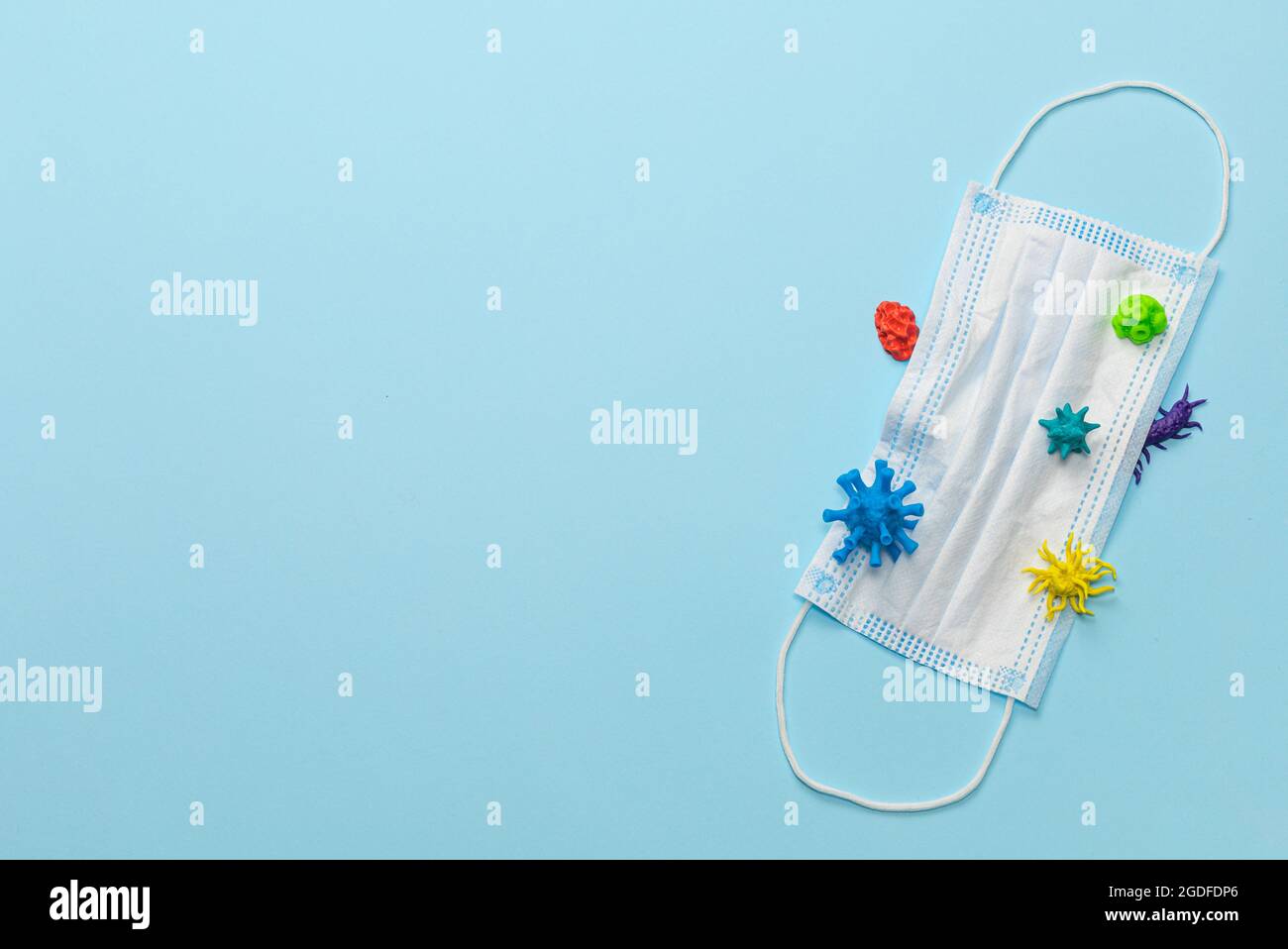 Maschera medica usata con virus e batteri cattivi. Vista dall'alto. Spazio di copia per il testo. Foto Stock