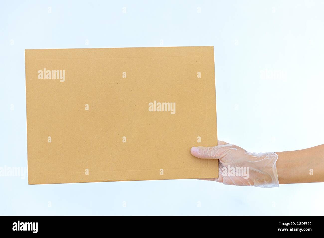 Una mano della donna tiene in guanti medici una busta di carta Amazon su sfondo bianco consegna espressa il corriere ha portato il pacchetto Foto Stock