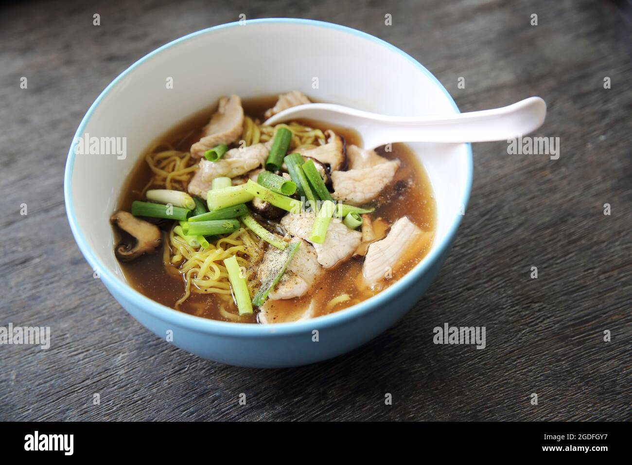 noodle con maiale su sfondo di legno Foto Stock