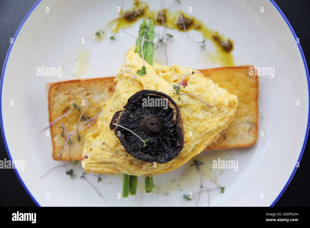 Uova strapazzate con asparagi di pane e funghi in primo piano Foto Stock