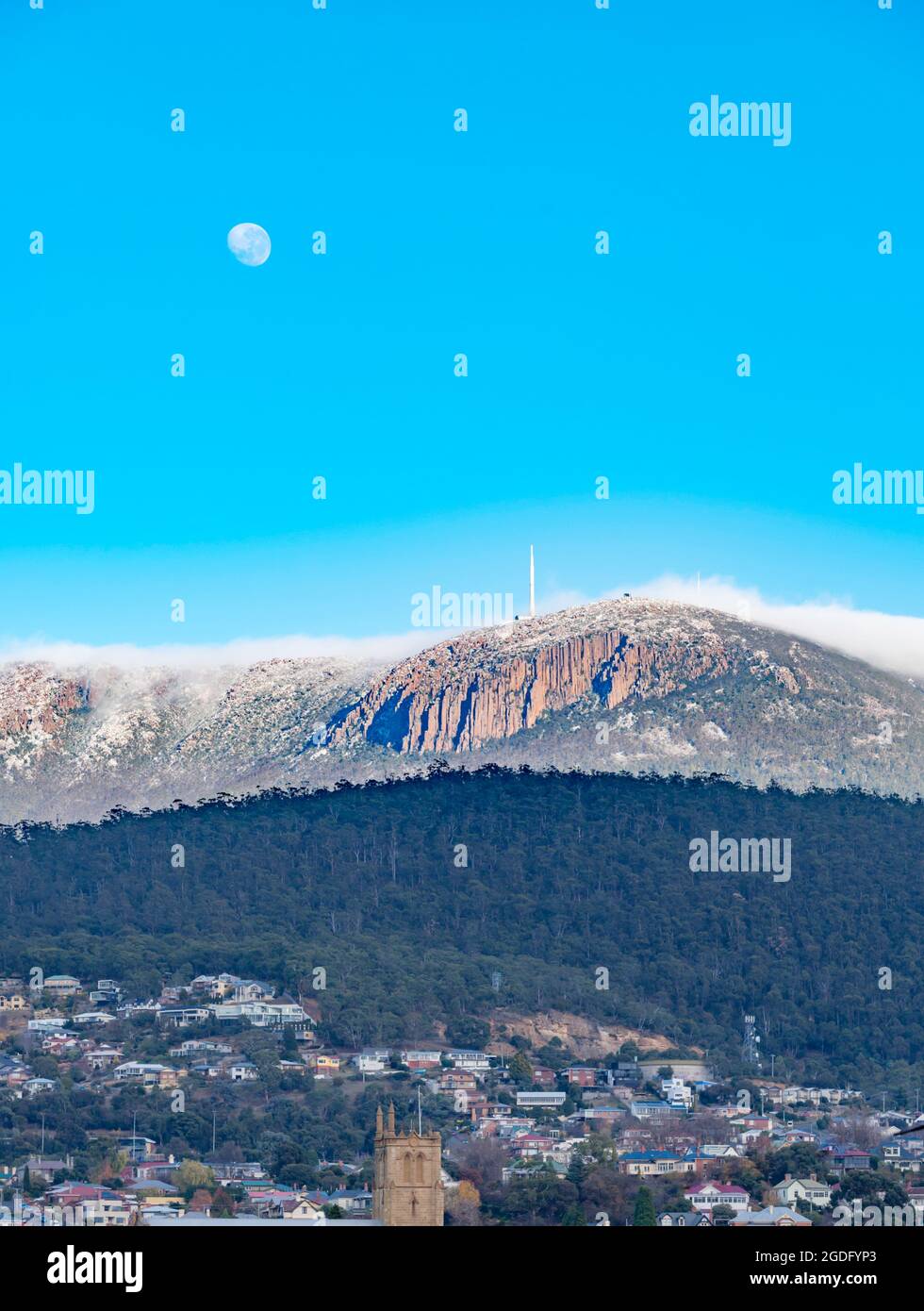Con la luna ancora su una coperta di nuvola di mattina presto rotola sopra Kunanyi (Monte Wellington) verso Hobart, la capitale della Tasmania in Australia Foto Stock