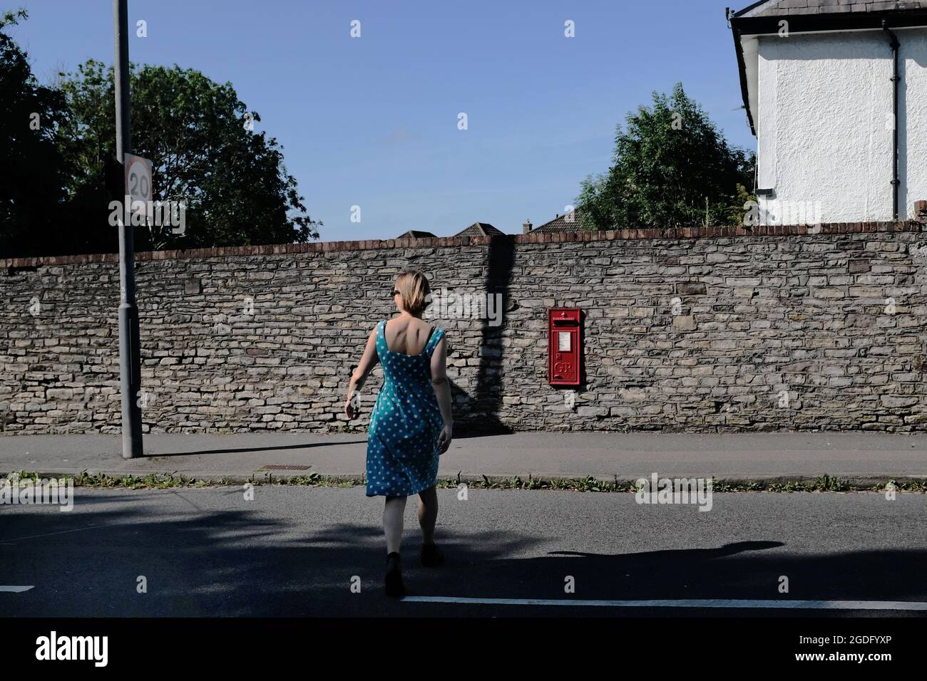 Una donna che attraversa la strada. Foto Stock