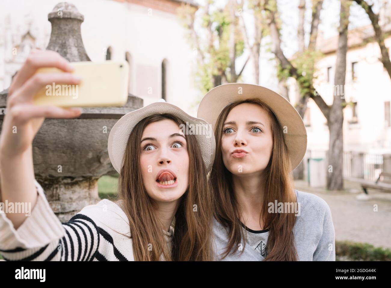 Fidanzate tenendo selfie in piazza, Belluno, Veneto, Italia Foto Stock