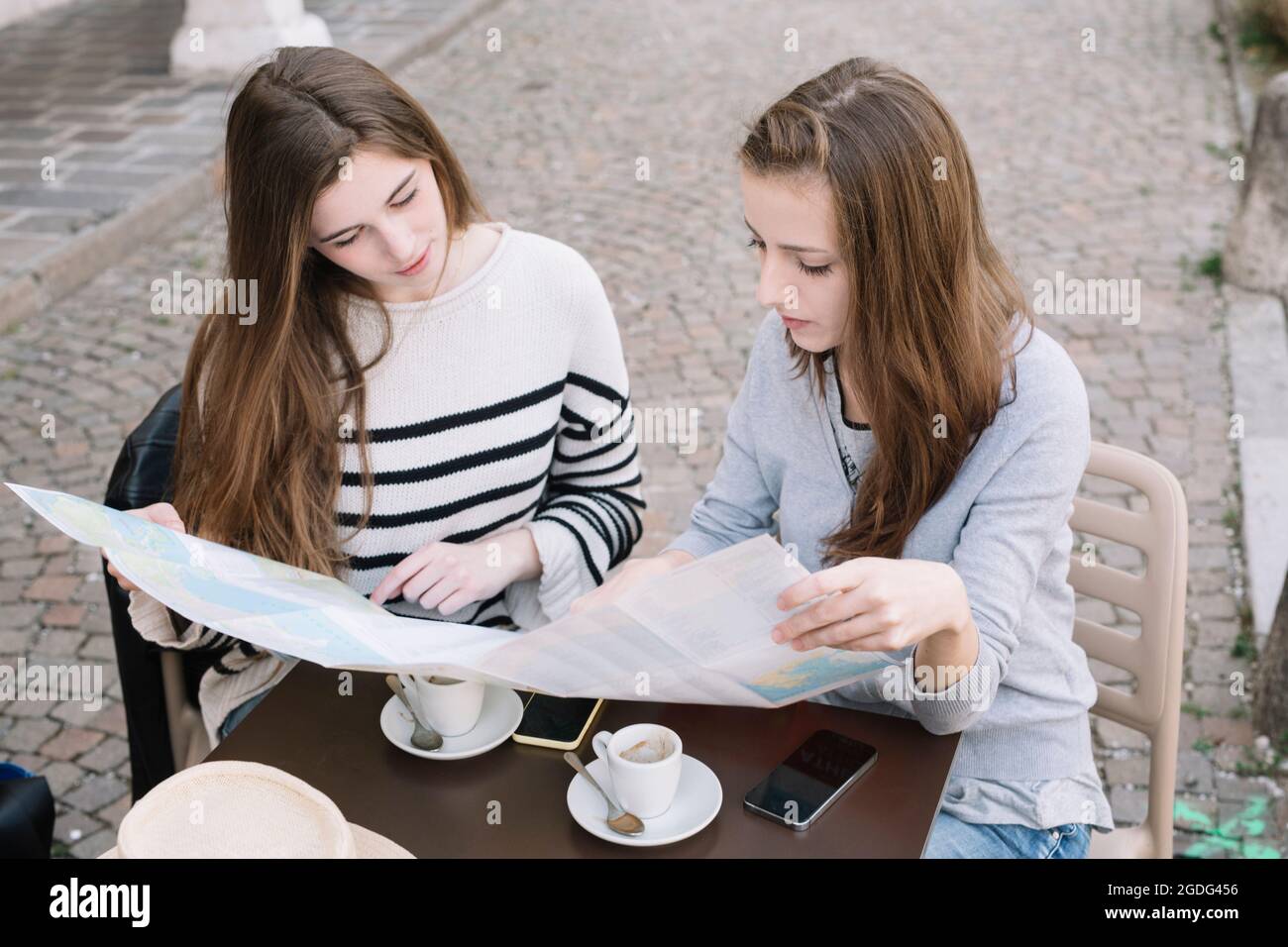 Lettura fidanzate mappa stradale presso il cafe Foto Stock