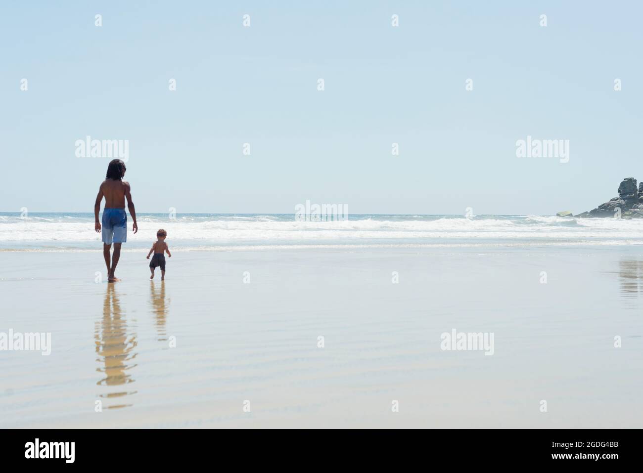 Padre e figlio camminando sulla spiaggia Foto Stock