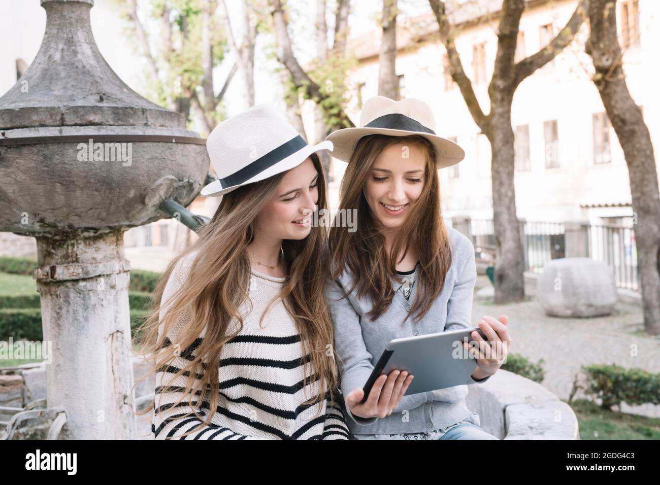 Fidanzate utilizzando digitale compressa in piazza, Belluno, Veneto, Italia Foto Stock