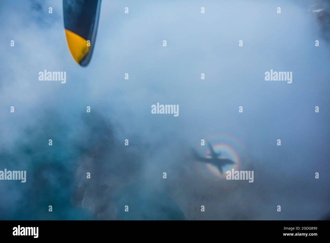 vista astratta dell'ombra di un aeroplano in un anello arcobaleno Foto Stock