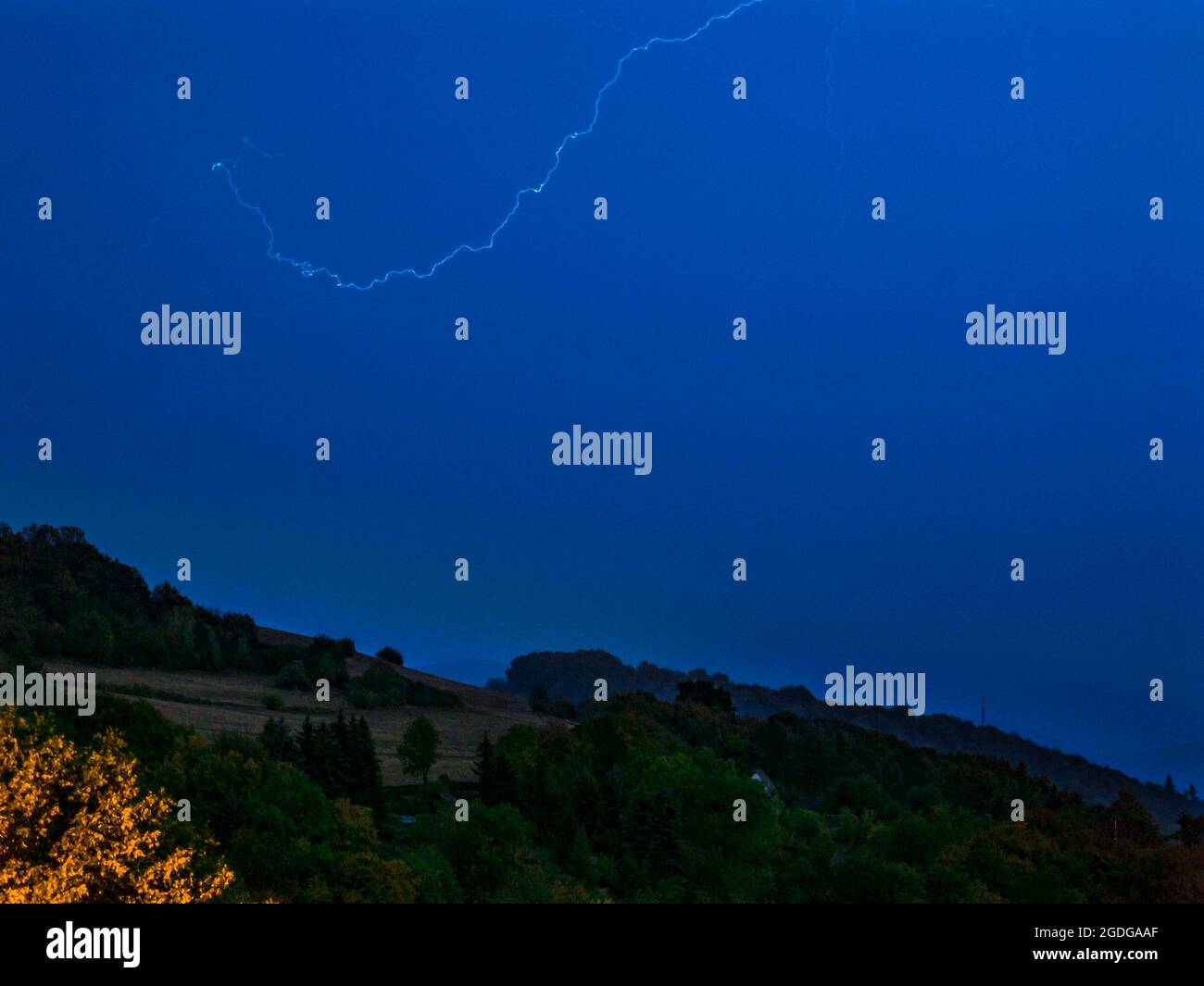 Flash nel cielo sopra il paesaggio collinare - lunga esposizione di notte Foto Stock