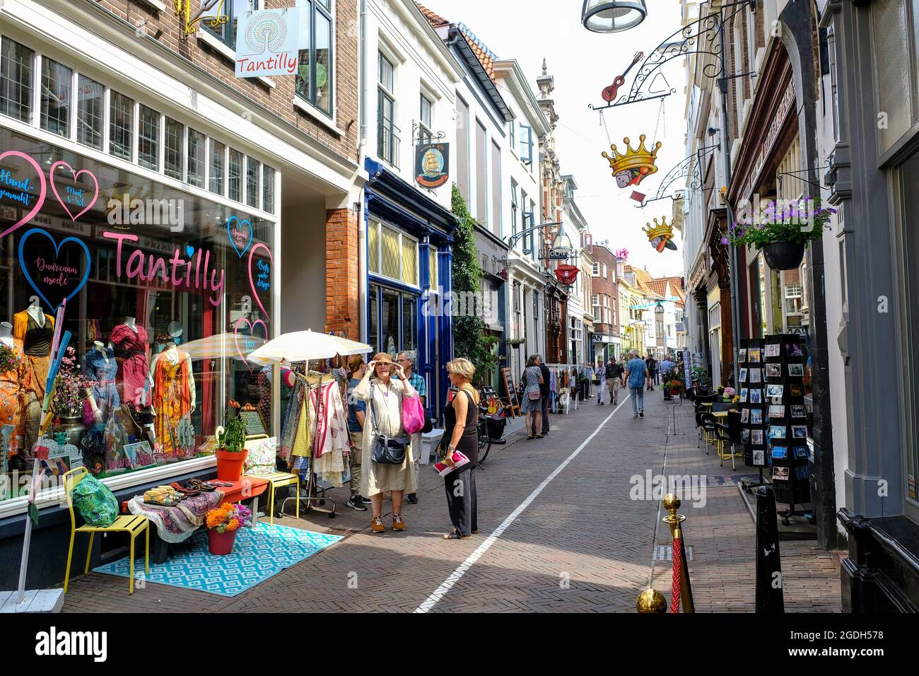 NLD, Niederlande, Overijssel, Deventer, 12.08.2021: Eine Frau probiert einen Hut auf in der Kleinen Overstraat in der Hansestadt Deventer in der Provincial Foto Stock
