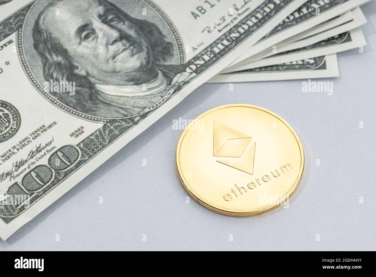 Moneta di Ethereum e un mucchio di banconote in dollari USA. Blockchain money vs. fiat money Concept Foto Stock