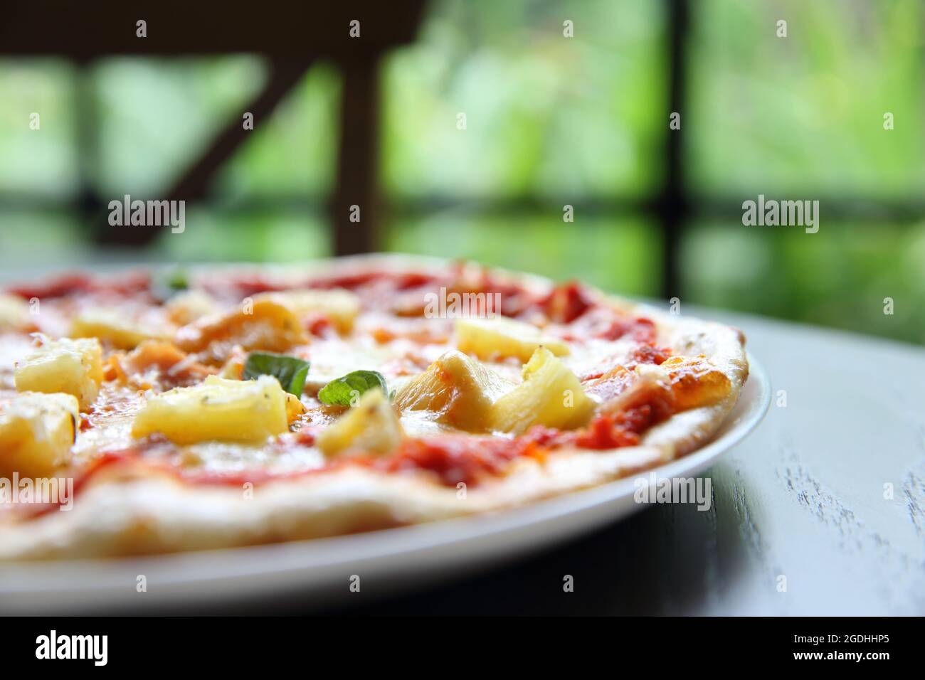 Pizza hawaiana, pizza con prosciutto formaggio ananas su sfondo legno Foto Stock