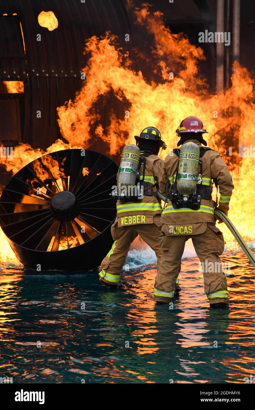 I vigili del fuoco assegnati al 628° Squadron dell'ingegnere civile lavorano insieme per spegnere un incendio durante un esercizio di combustione dal vivo il 30 marzo 2021 presso la Joint base Charleston, S.C. gli specialisti della protezione antincendio partecipano a questo esercizio ogni tre mesi per rinnovare la loro preparazione alla formazione. Il sito di addestramento è l'unica sede disponibile con capacità di incendio simulate su JB Charleston. (STATI UNITI Air Force foto di Airman prima Classe Jade Dubiel) Foto Stock