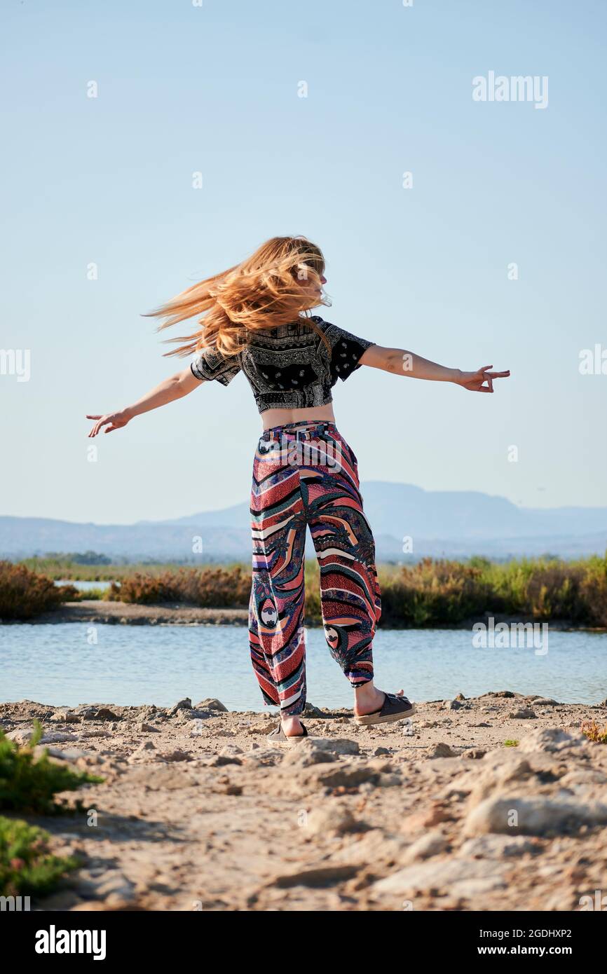 La giovane donna danzava con un salino sullo sfondo Foto Stock