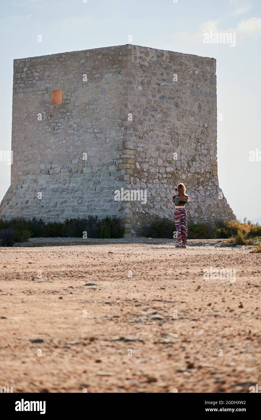 Donna scatta foto con il telefono della Torre del Tamarit, Spagna Foto Stock