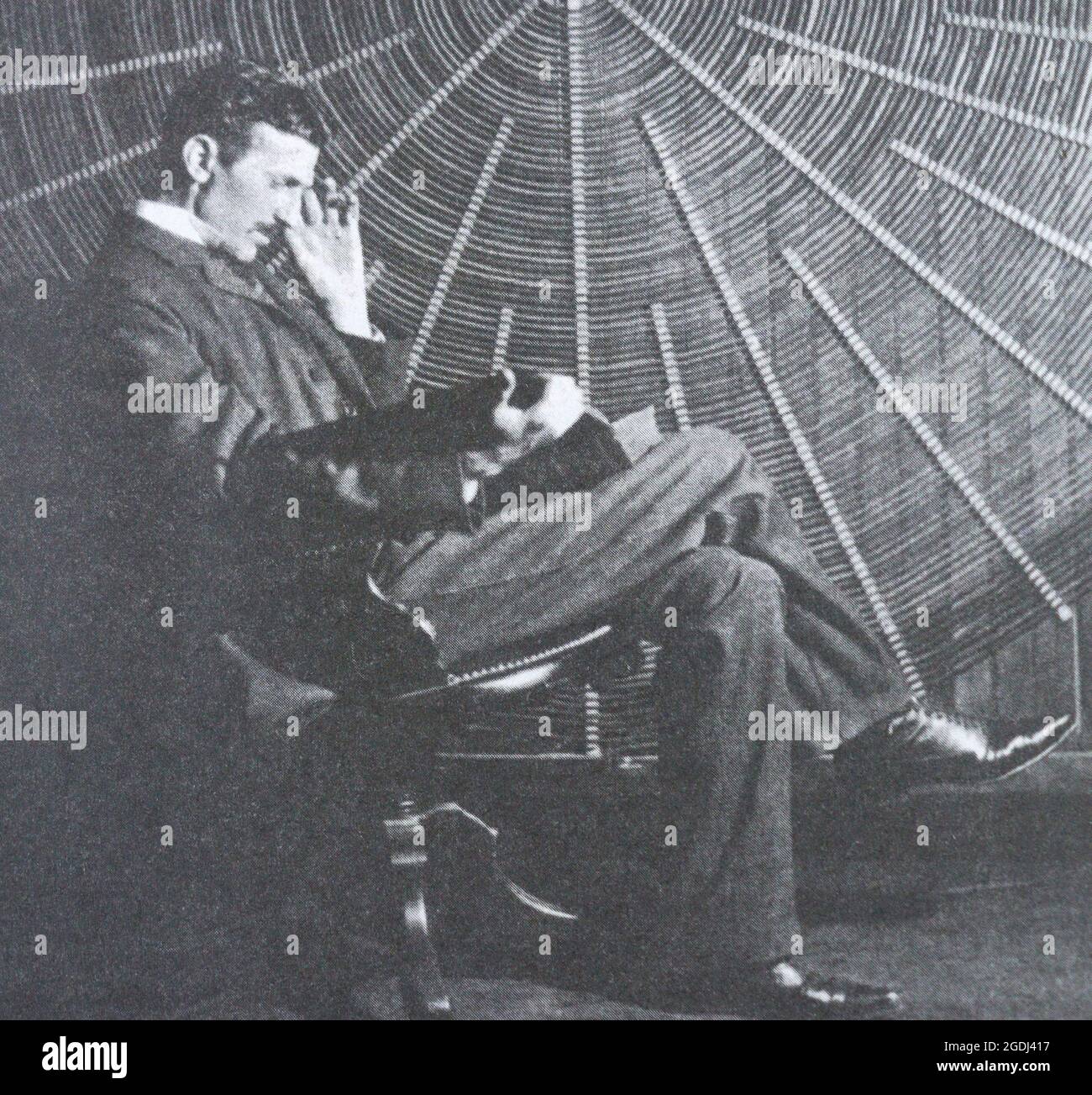 Nikola Tesla vicino alla bobina a spirale del suo trasformatore ad alta frequenza. Foto Stock