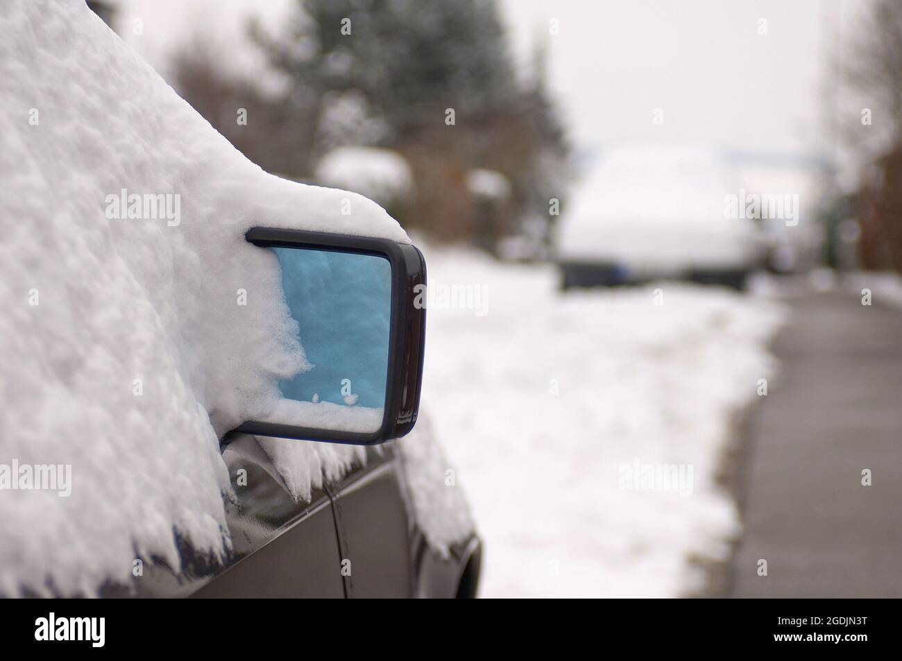 Auto coperta di neve sul lato della strada, specchio retrovisore in direzione di neve, Germania Foto Stock