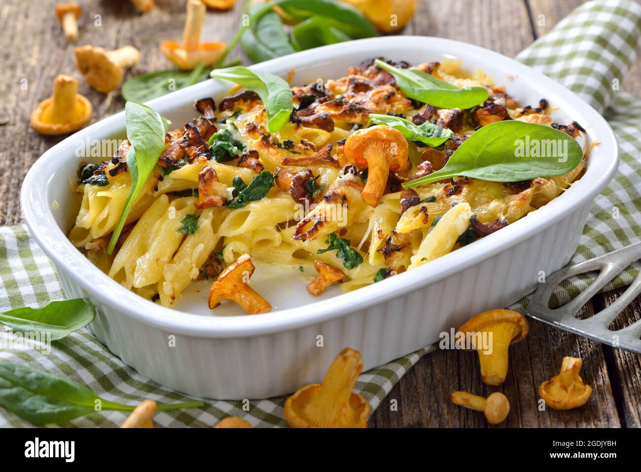 Casseruola di pasta chanterelle con foglie di spinaci e formaggio servito caldo dal forno Foto Stock