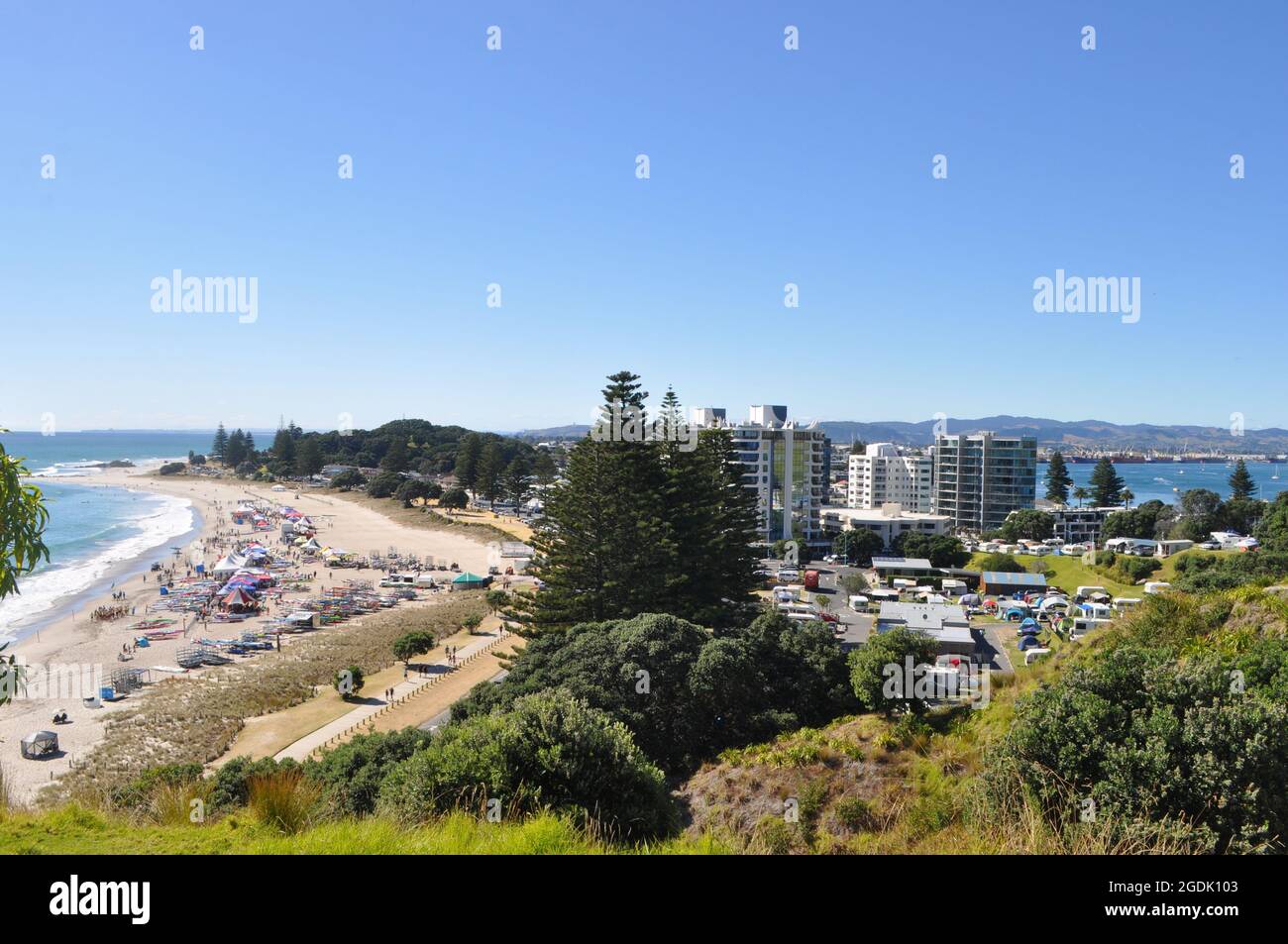 Una folla di persone ama il surf alla spiaggia di Tauranga, Nuova Zelanda Foto Stock